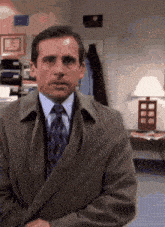 a man in a suit and tie is sitting in an office