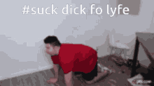 a man in a red shirt is crawling on the floor with the words #suck dick fo lyfe behind him