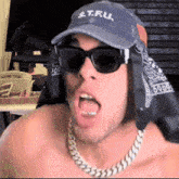 a shirtless man wearing sunglasses and a hat that says e.t.ru.