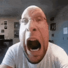 a man with glasses is making a funny face with his mouth wide open .