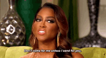 a woman is sitting on a green couch and saying `` don t come for me unless i send for you '' .