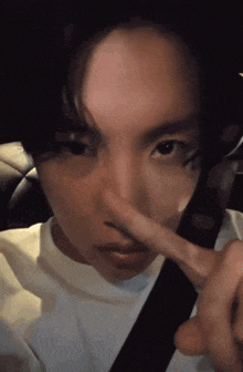 a close up of a person holding their nose with their finger