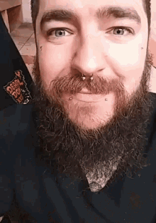 a man with a beard and piercings is wearing a shirt that says death squad on it