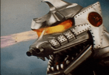 a close up of a robot 's head with fire coming out of its mouth