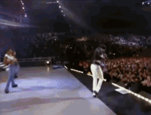 a man is dancing on a stage in front of a crowd of people
