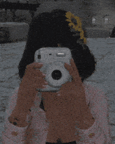 a woman in a pink jacket is taking a picture of herself with a camera