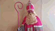 a statue of a man in a pink costume with a cane