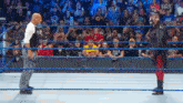 a wrestler is standing in a wrestling ring with a referee .