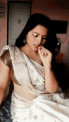 a woman in a white saree with a tattoo on her arm