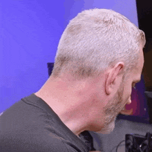 a man with gray hair and a beard is looking at something