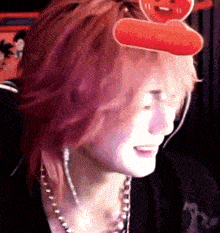 a close up of a person 's face with a red balloon on their head