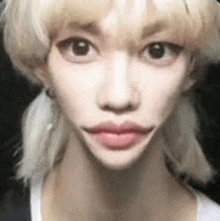 a close up of a woman 's face with a ponytail and a big mouth .
