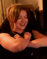 a woman is smiling with her eyes closed
