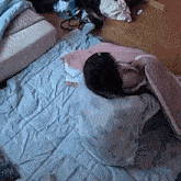a woman is laying on a bed wrapped in a blanket