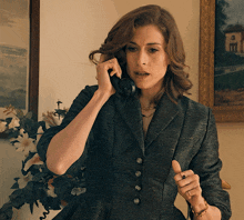a woman in a suit talking on a phone