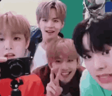 a group of young men are posing for a picture with a camera and smiling .
