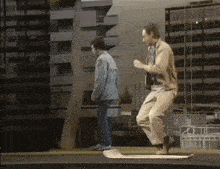 a man is riding a skateboard with another man standing behind him