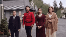 a group of people are standing in front of a building that says ' s ' on it