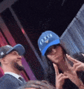a man and a woman are posing for a picture and the woman is wearing a hat that says ' arizona '