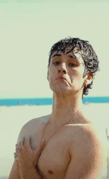 a man without a shirt is standing on the beach