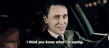 a man in a suit and tie is sitting in a car and says i think you know what i 'm saying