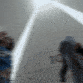 a blurry picture of a person standing in front of a white wall