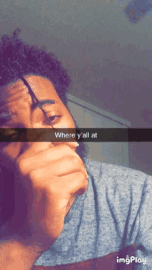 a man smoking a cigarette with a caption that says " where y 'all at "