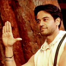 a man with a ring on his finger holds his hand up in the air