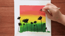 a person is painting flowers with a brush