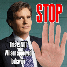 a man in a suit and tie is making a stop gesture with his hand