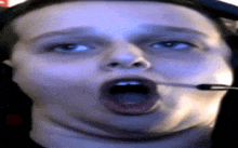 a close up of a person wearing headphones with their mouth open .