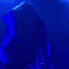 a blurry picture of a person dancing in a dark room .