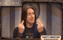 a man with long hair is giving the middle finger in front of a critical role sign .