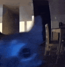 a room with a table and chairs and a blue light coming out of the door