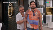 two men standing next to each other in front of a sign that says masterchef argentina