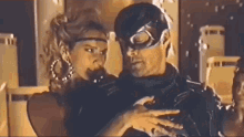 a man wearing a mask is holding a woman