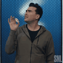 a man in a hoodie is holding a football in his hand and says why