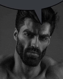 a black and white photo of a man with a beard and a speech bubble above his head .