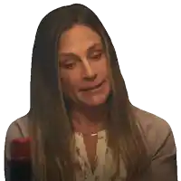a woman with long hair is holding a bottle and making a face