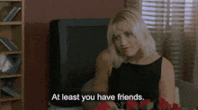 a woman sitting in front of a television with the words at least you have friends
