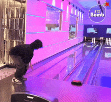 a bowling alley with purple walls and a sticker that says ' bts bomb ' on it