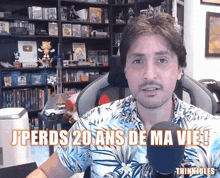 a man sitting in front of a microphone with the words " j'perds 20 ans de ma vie "