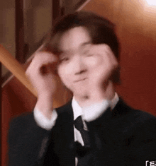 a man wearing a suit and tie is making a funny face .