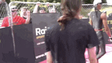 a woman holding a sign that says rai sports on it