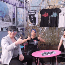 three women are giving a thumbs up in front of a sign that says koelsche kliuengel
