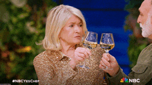 a woman and a man are toasting with wine glasses and the nbc logo is visible