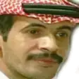 a man with a mustache wearing a red and white checkered hat .