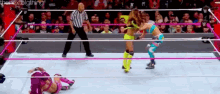 two women are wrestling in a wrestling ring with a referee watching .