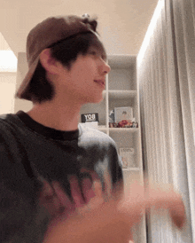 a young man wearing a baseball cap and a t-shirt that says yqb