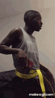 a man is wearing a yellow belt with make a gif.com on the bottom right